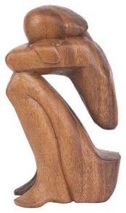 Carved wooden figure of a seated person resting their head on their arms